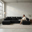 Front view of black U-shaped corduroy sectional sofa with double chaise in a living room setting