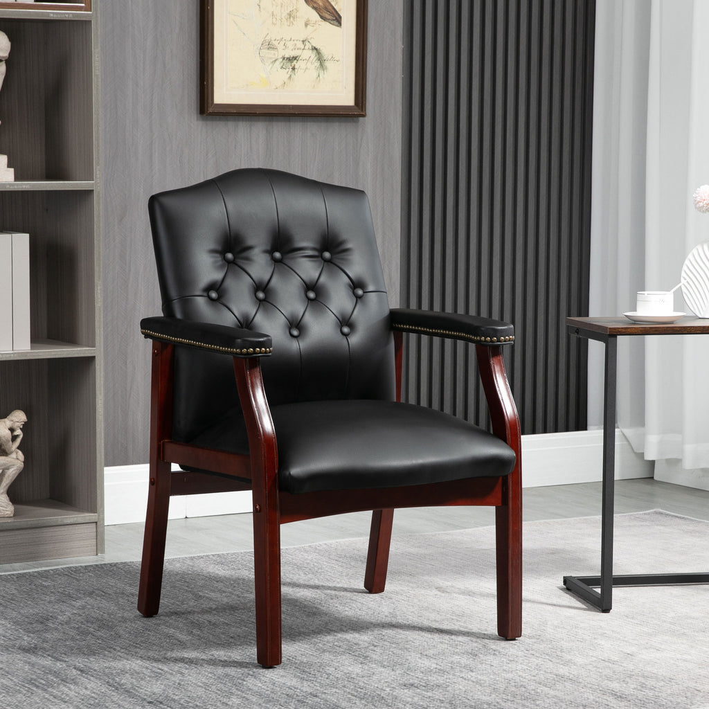 Front view of black leather guest chair with padded arms and button-tufted seat