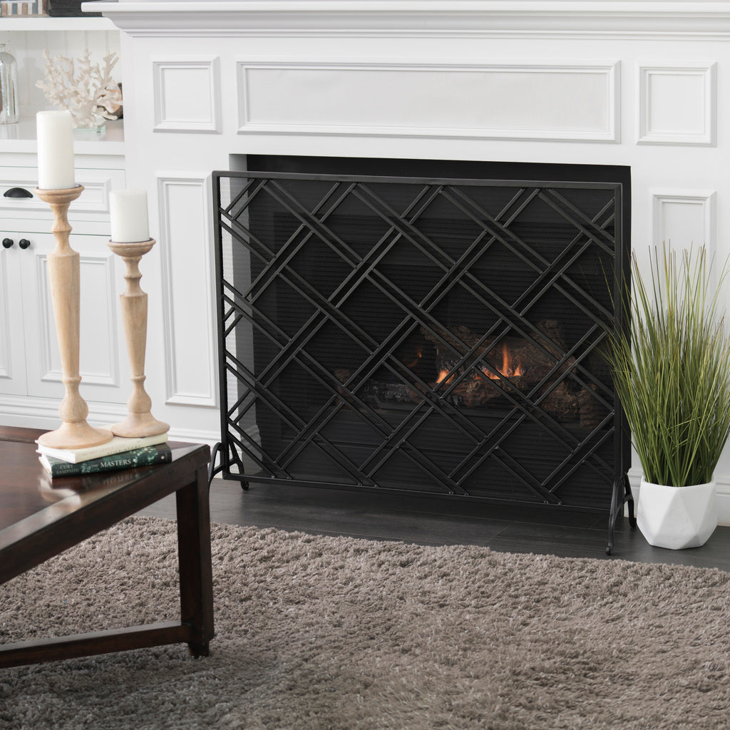 Front view of black iron fireplace fire screen showing scrollwork design and freestanding frame