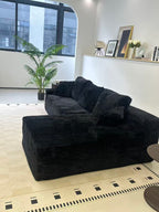 Black L-shaped sofa placed in a modern living room setting