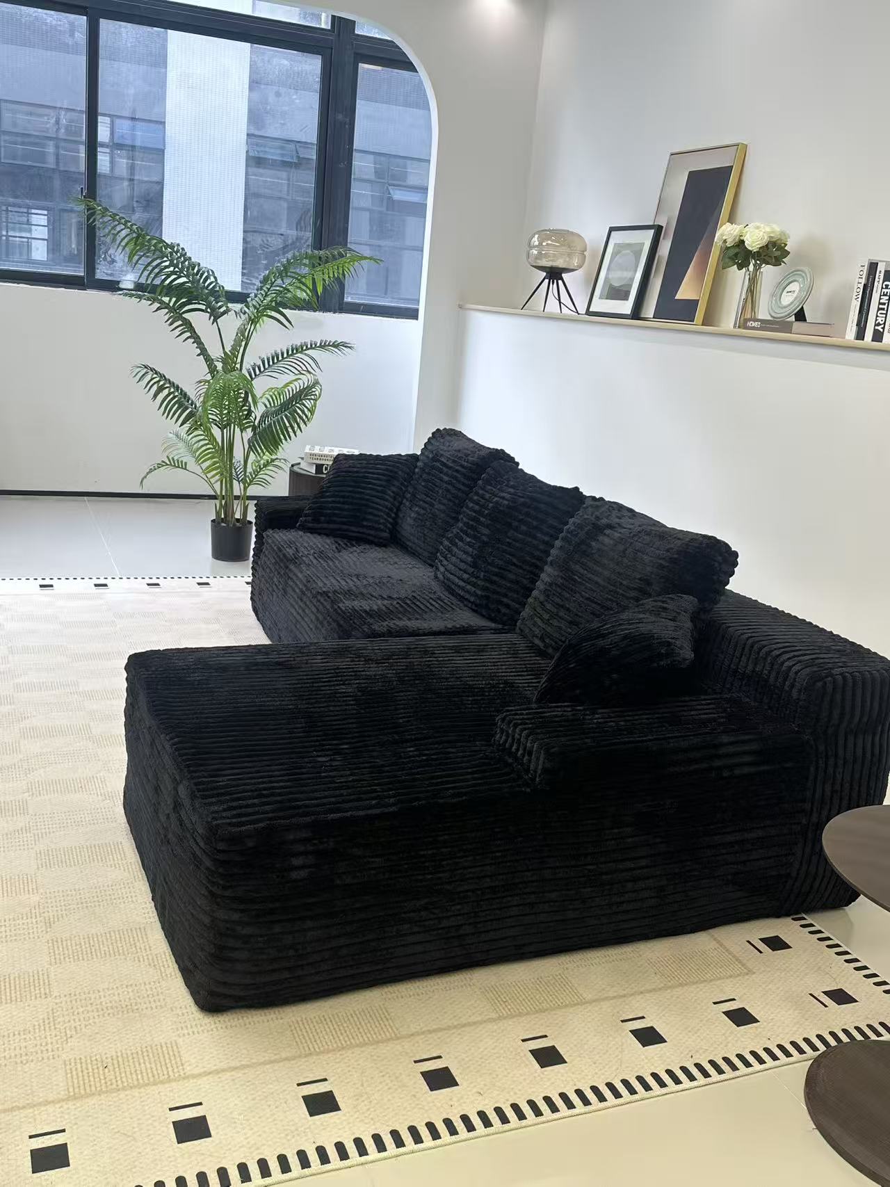 Black L-shaped sofa placed in a modern living room setting