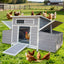 Front view of a large grayish purple wooden chicken coop with open front door and visible nesting boxes