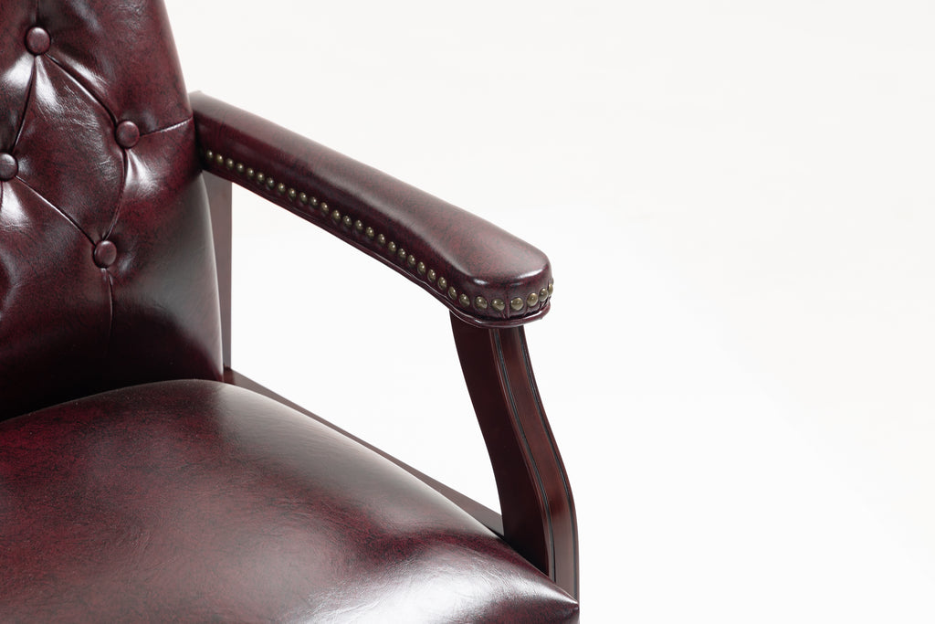 Side view showing mid-back ergonomic support, padded armrests, and mahogany wood frame