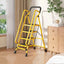 Front view of yellow 4-step folding ladder with handrails and wide pedals