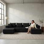 Front view of black U-shaped corduroy sectional sofa with double chaise in a living room setting